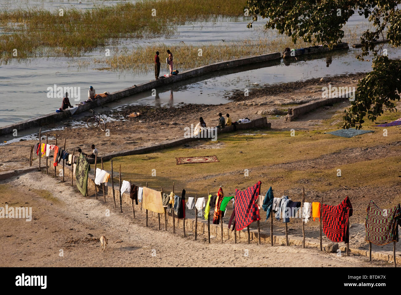 Locals gathered at Lake Awassa to do their washing with colourful garments hanging on a fence to dry Stock Photo