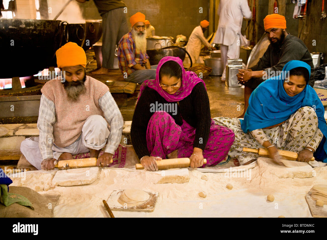 Dozens of volunteers help out as cooks and Chapati makers at the Golden Temple's kitchen, Amritsar, Punjab, India Stock Photo