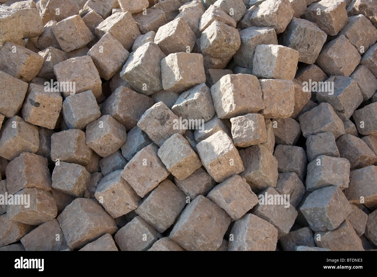 Hand-hewn cobblestones ready for laying Stock Photo