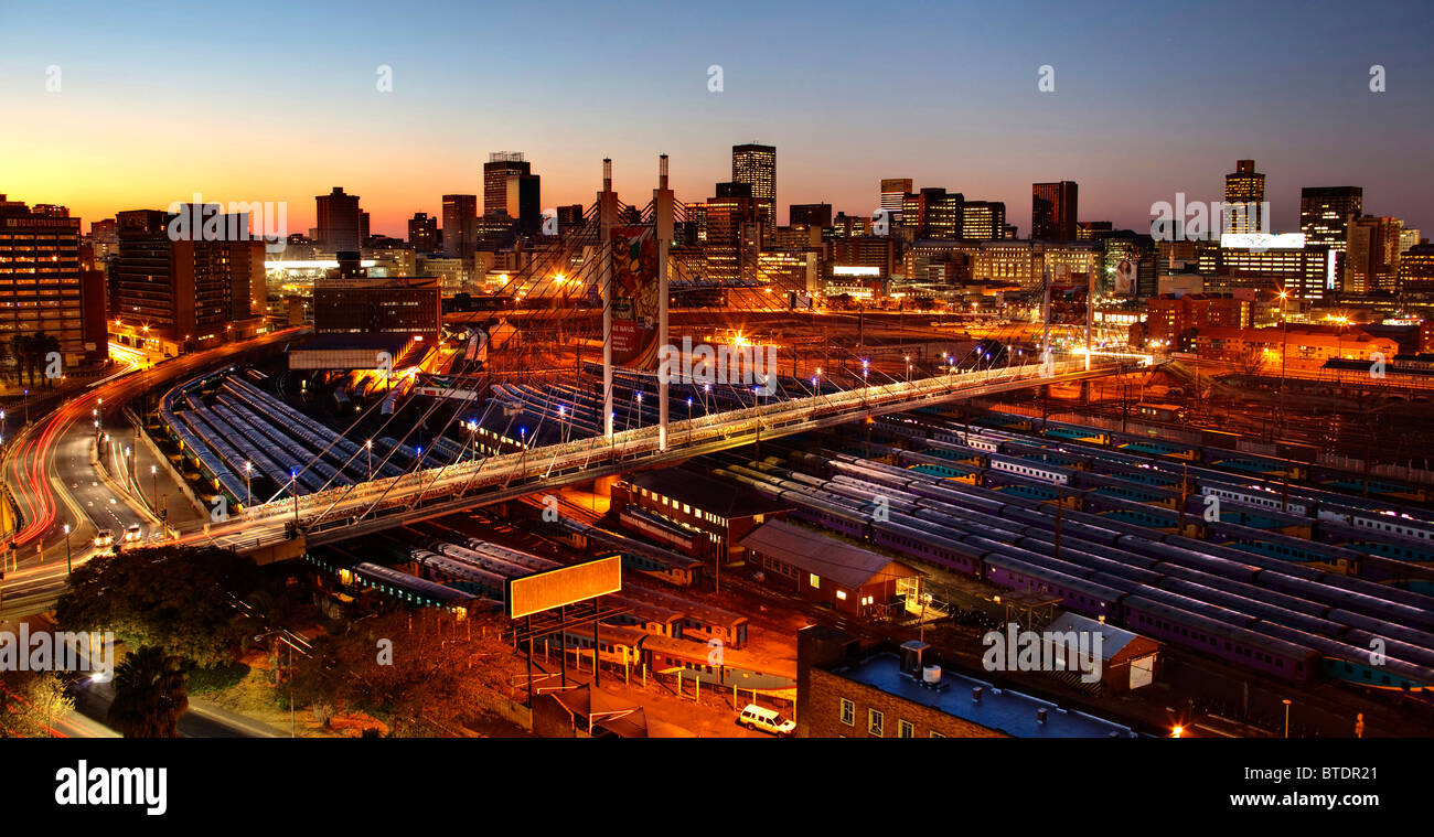 Sunrise over the city of Johannesburg with Nelson Mandela Bridge and the rail yards of Park Station. Stock Photo