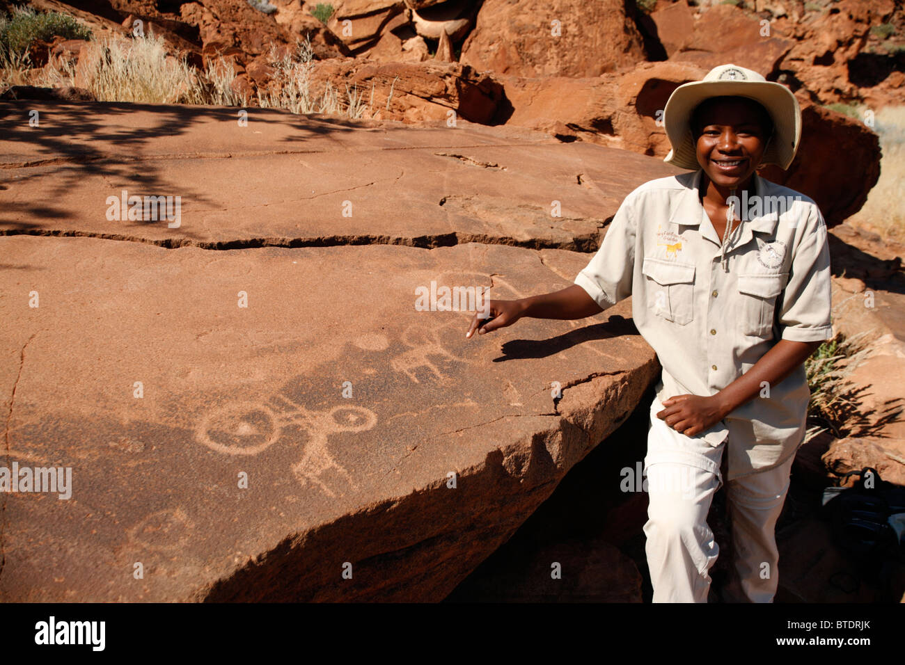 Local guide pointing out San rock art Stock Photo