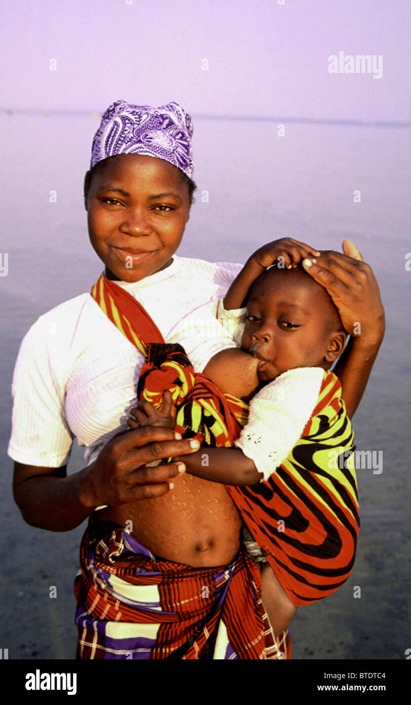 Mozambican woman carrying her young child in a sling and breast-feeding  Stock Photo - Alamy