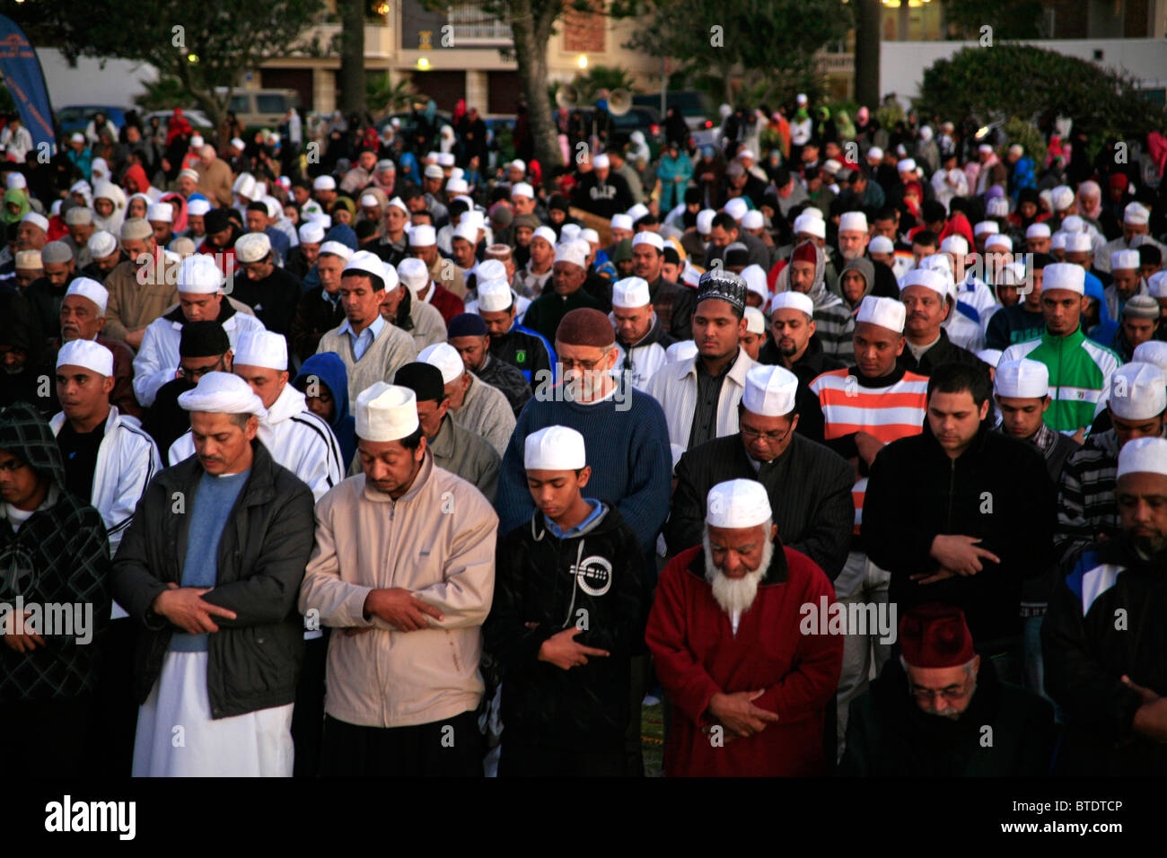 Muslim men wearing prayer caps pray before the first sighting of the moon  signifying the end of the Ramadan fast Stock Photo