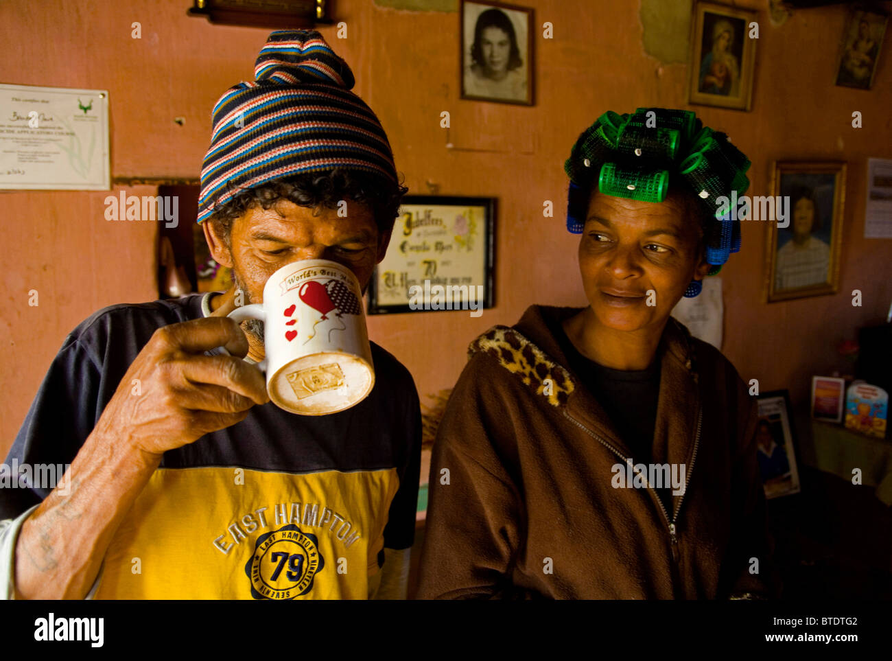 Man drinking coffee as his wife looks on, Elim,  Moravian mission village Stock Photo
