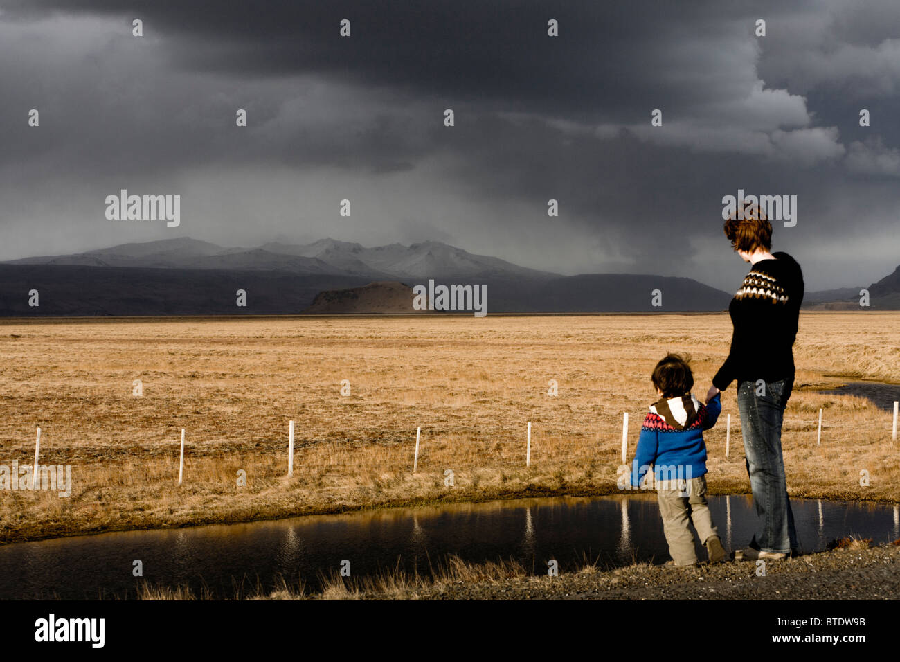 Mother and son looking at Stori-Dimon and Tindfjallajokull glacier, South Iceland. Stock Photo