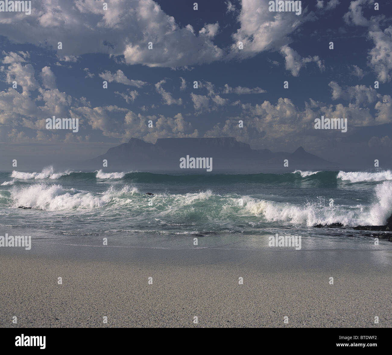 Table Mountain viewed front the beach at Blouberg with lots of cloud and rough sea Stock Photo