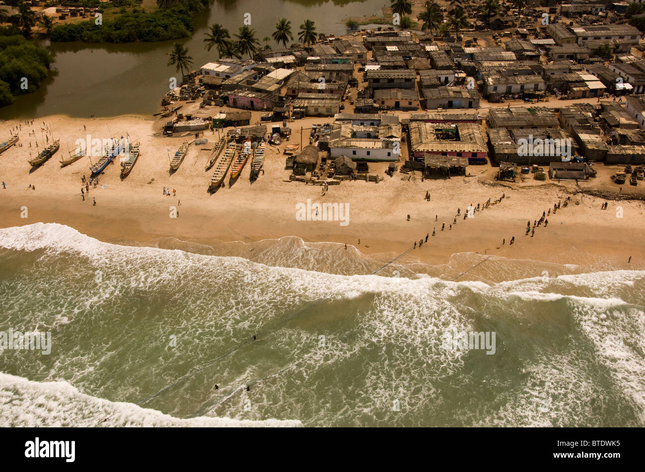 Birds eye view of a small fishing settlement bustling with activity, in the Ghanaian coastal region of Cape Coast. Stock Photo
