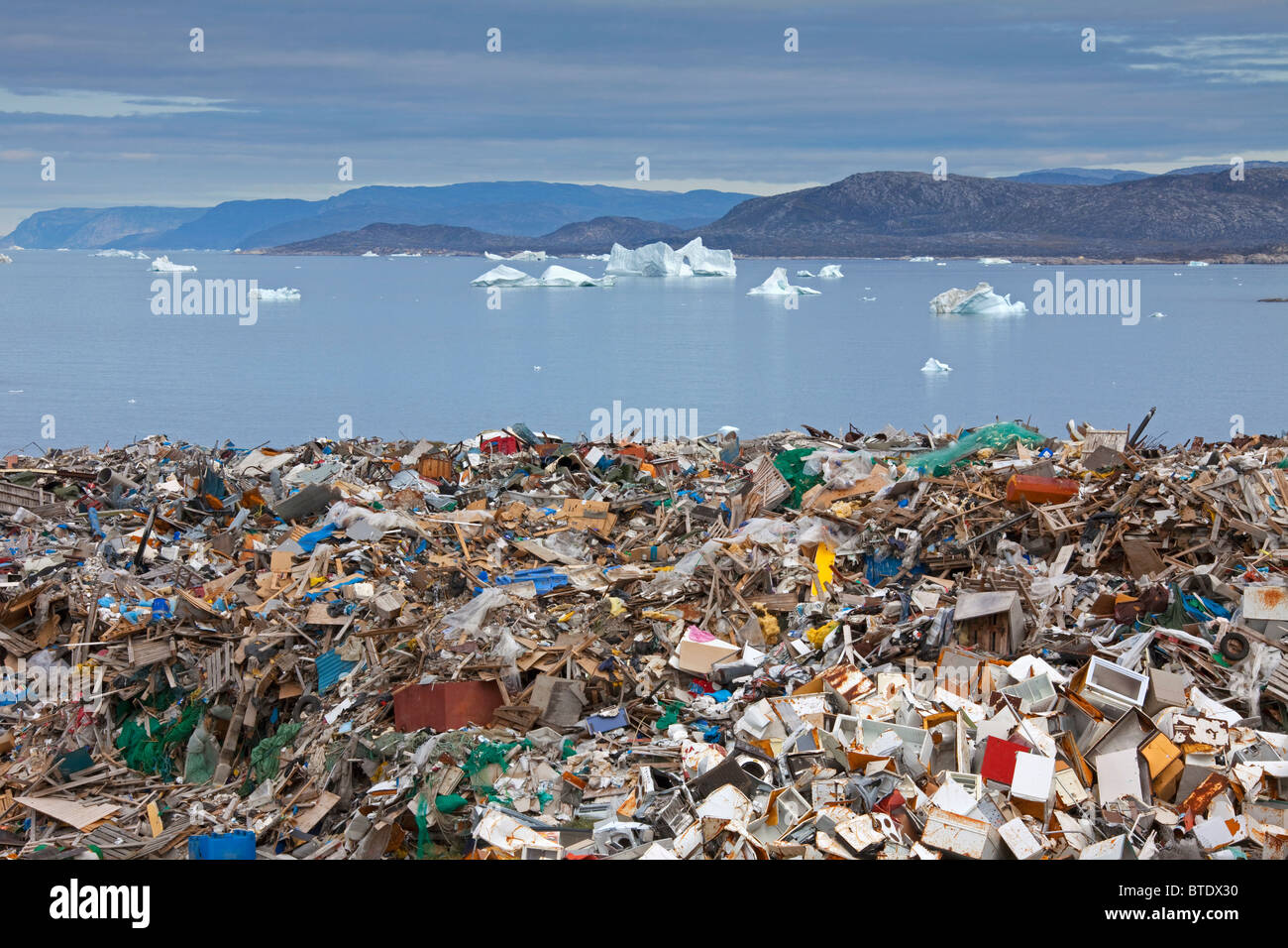 Rubbish at garbage dump and icebergs at Ilulissat / Jakobshavn, Disko-Bay, Greenland Stock Photo