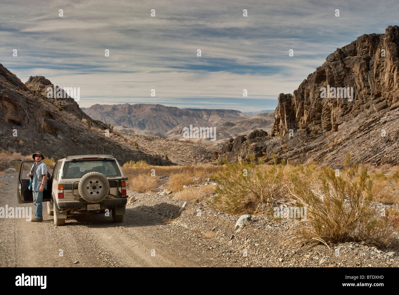 Traveler and 4WD vehicle at Hidden Valley Road at Mojave Desert in Death Valley National Park, California, USA Stock Photo