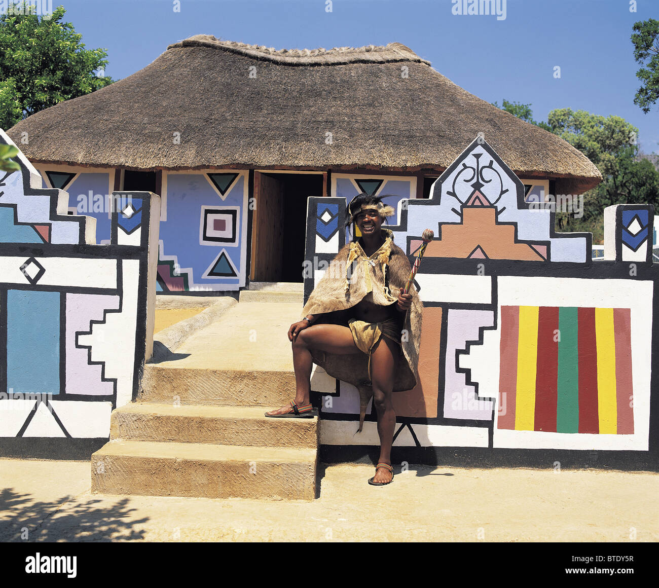 A proud Ndebele man stands outside the entrance to his house Stock Photo