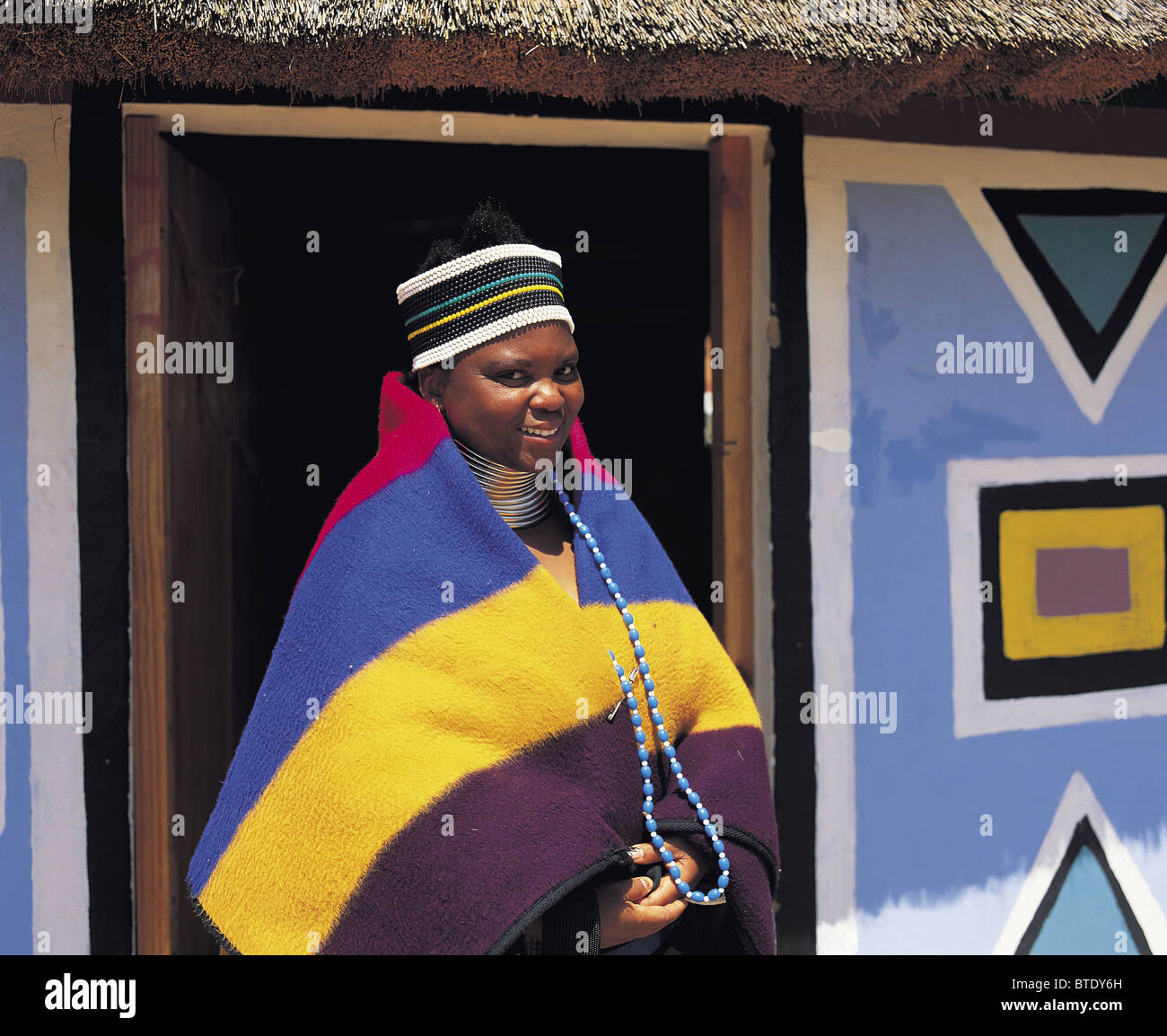 A Ndebele woman standing at the entrance to her house Stock Photo