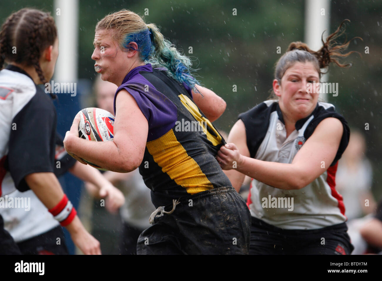 An Eastern Carolina University rugby player carries the ball against Northeastern University during a women's match. Stock Photo