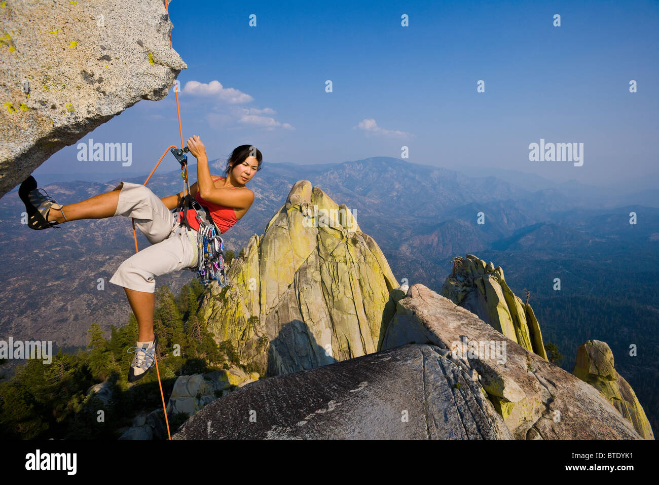 Female climber rappelling from the summit of an overhanging cliff Stock ...