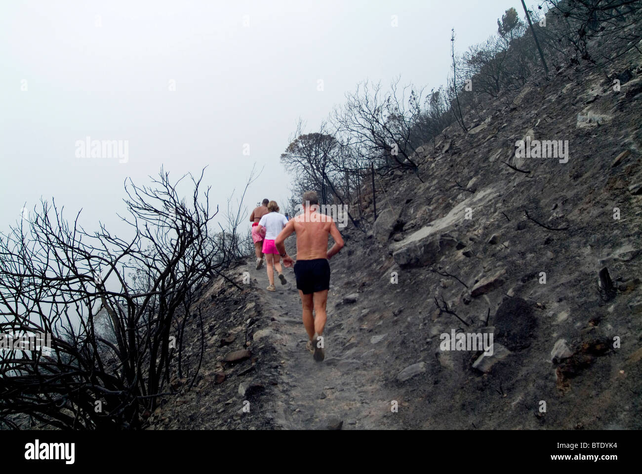 A group of runners on a burnt mountainside Stock Photo
