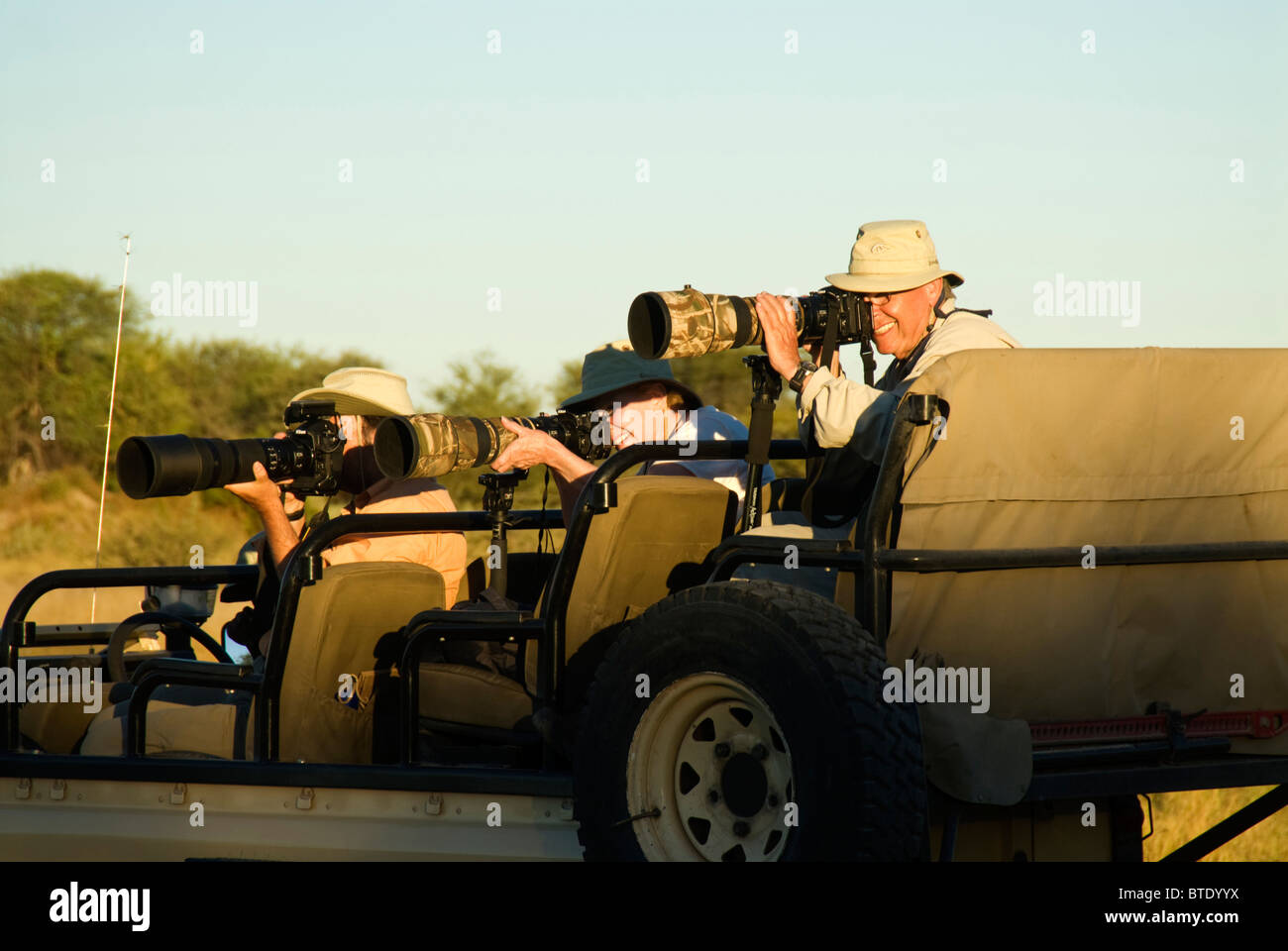 Tourists in safari vehicle taking photographs Stock Photo