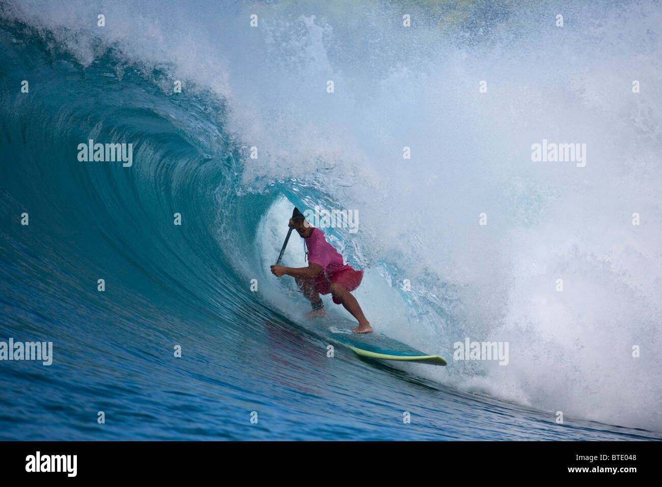 Man surfing in the tube of a wave Stock Photo