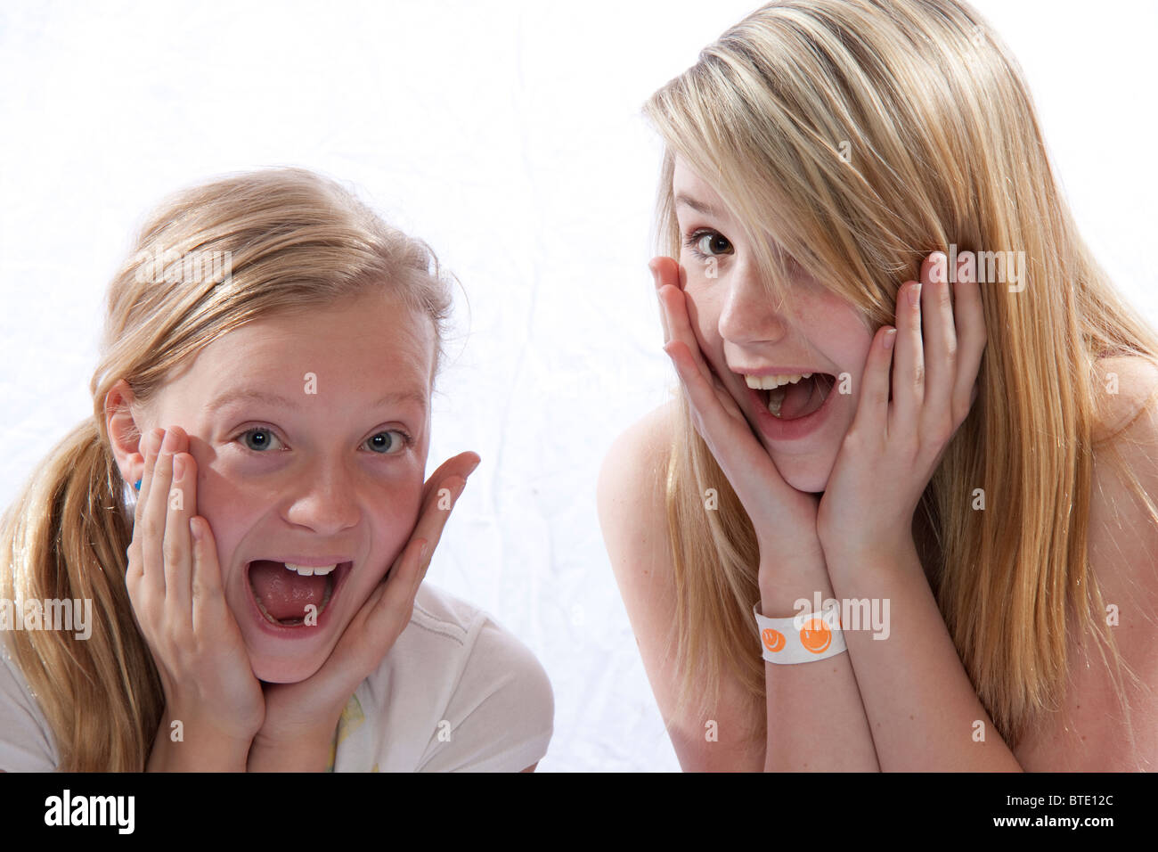 Excited, surprised girls with hands on cheeks Stock Photo - Alamy