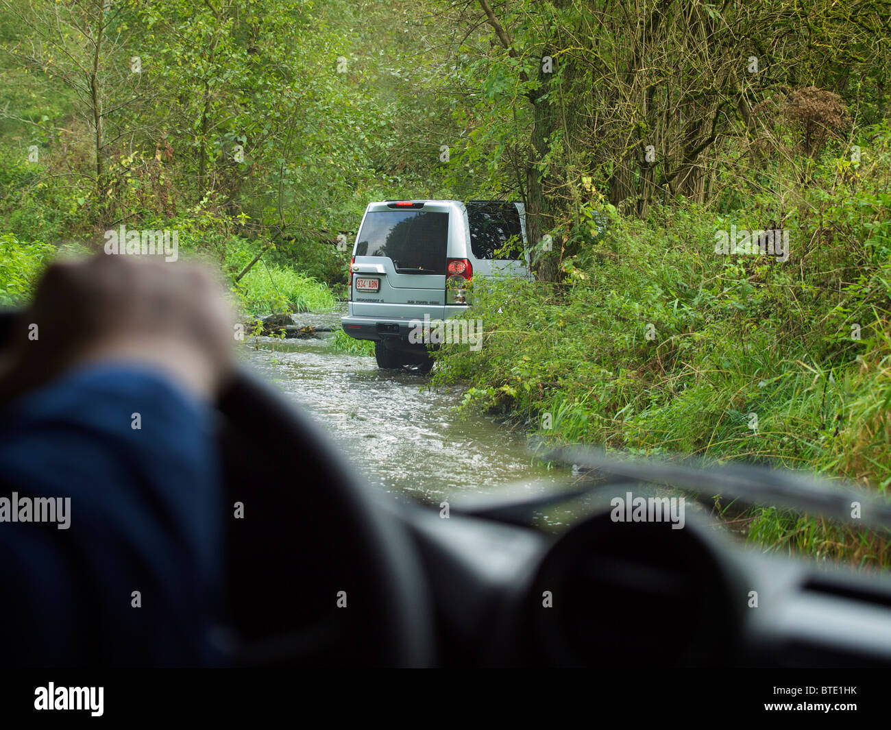 Driver's view of Land Rover Discovery 4 driving through a river at the Domaine d'Arthey estate in Belgium Stock Photo