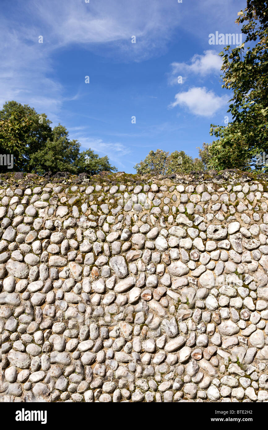 Traditional Norfolk flint stone knapped boundary wall and a bright summer sky in Norfolk, East Anglia, England Stock Photo