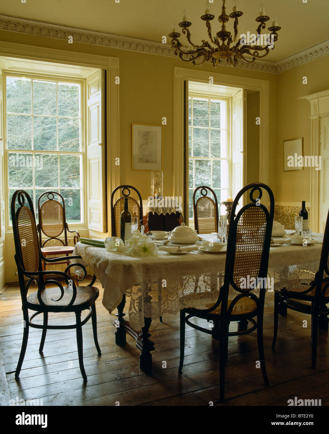 Antique Bentwood chairs at table set for lunch with white lace cloth in