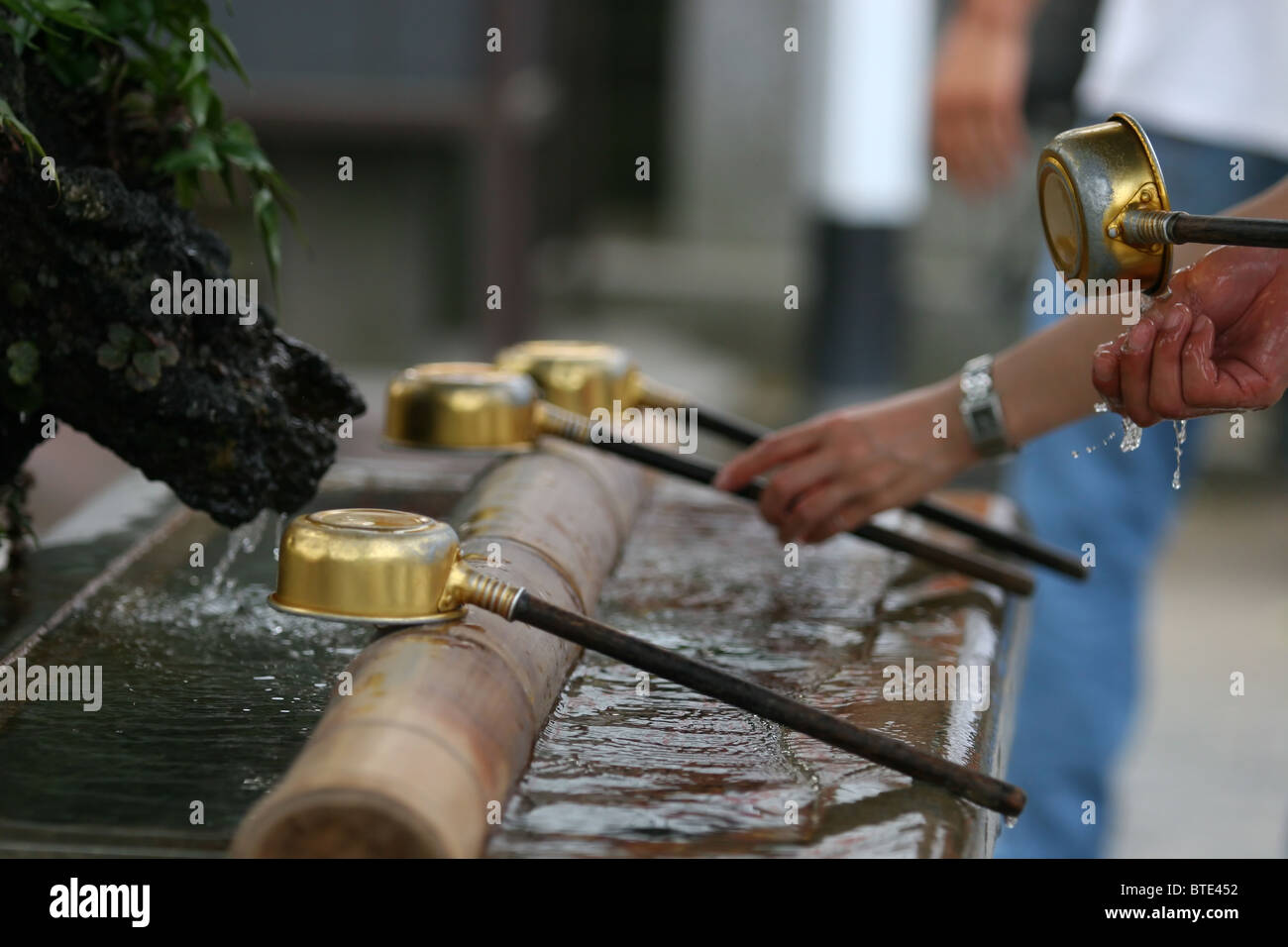 Washing hands before entering a Buddhist temple in Tokyo, Japan Stock