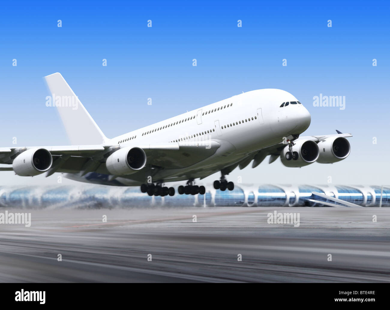 white passenger airplane in the blue sky landing away Stock Photo - Alamy