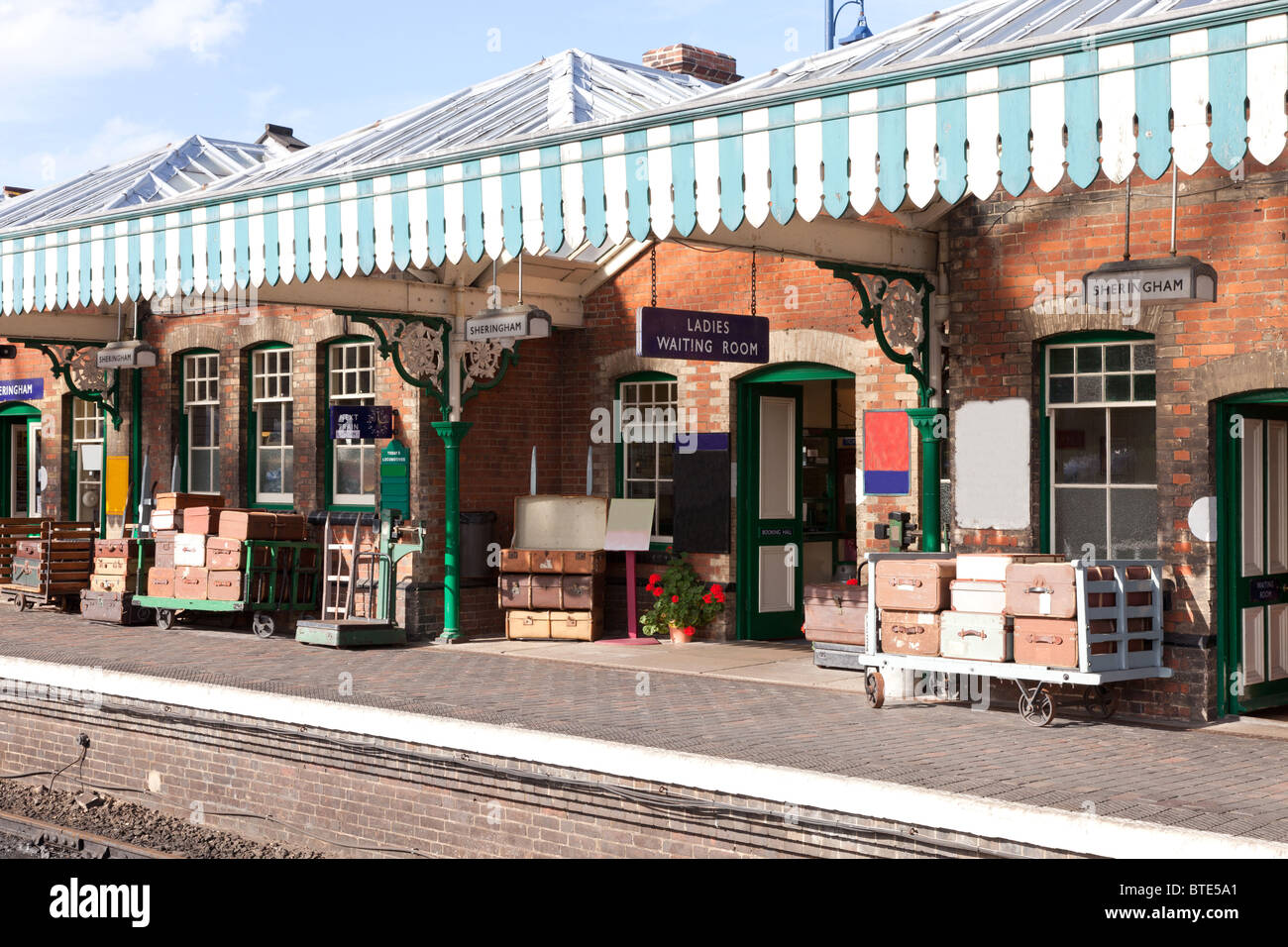Old fashioned railway station with traditional luggage trollies and old style suitcases at Sheringham, Norfolk, England Stock Photo