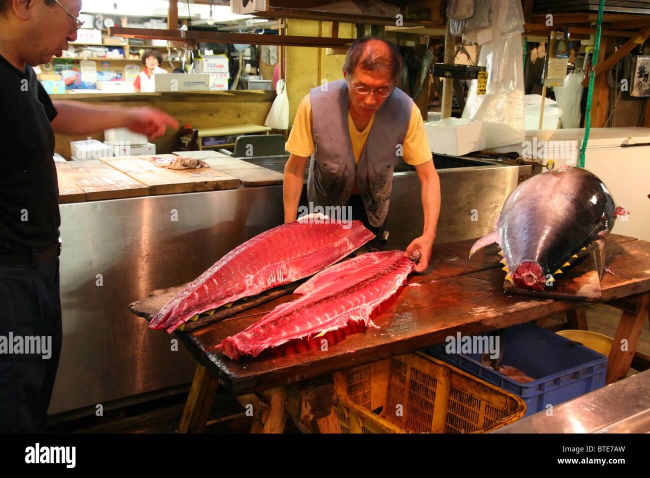 Japanese fishmongers cutting a blue fin tuna in Tsukiji fish market in