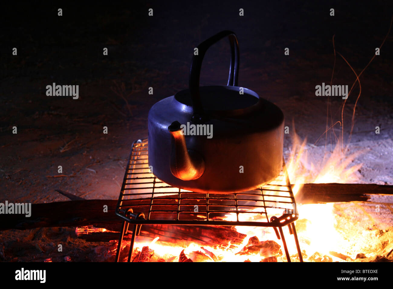 https://c8.alamy.com/comp/BTEDXE/a-kettle-on-a-grid-with-a-log-fire-beneath-it-BTEDXE.jpg
