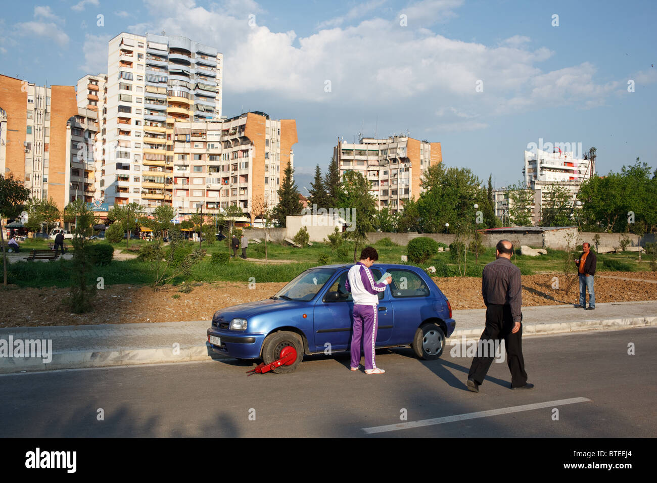 A woman with a traffic ticket and her car clamped with wheel clamp due
