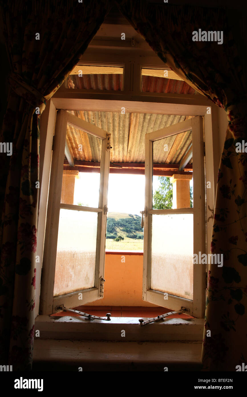 View from inside a rustic farmhouse through an open window Stock Photo