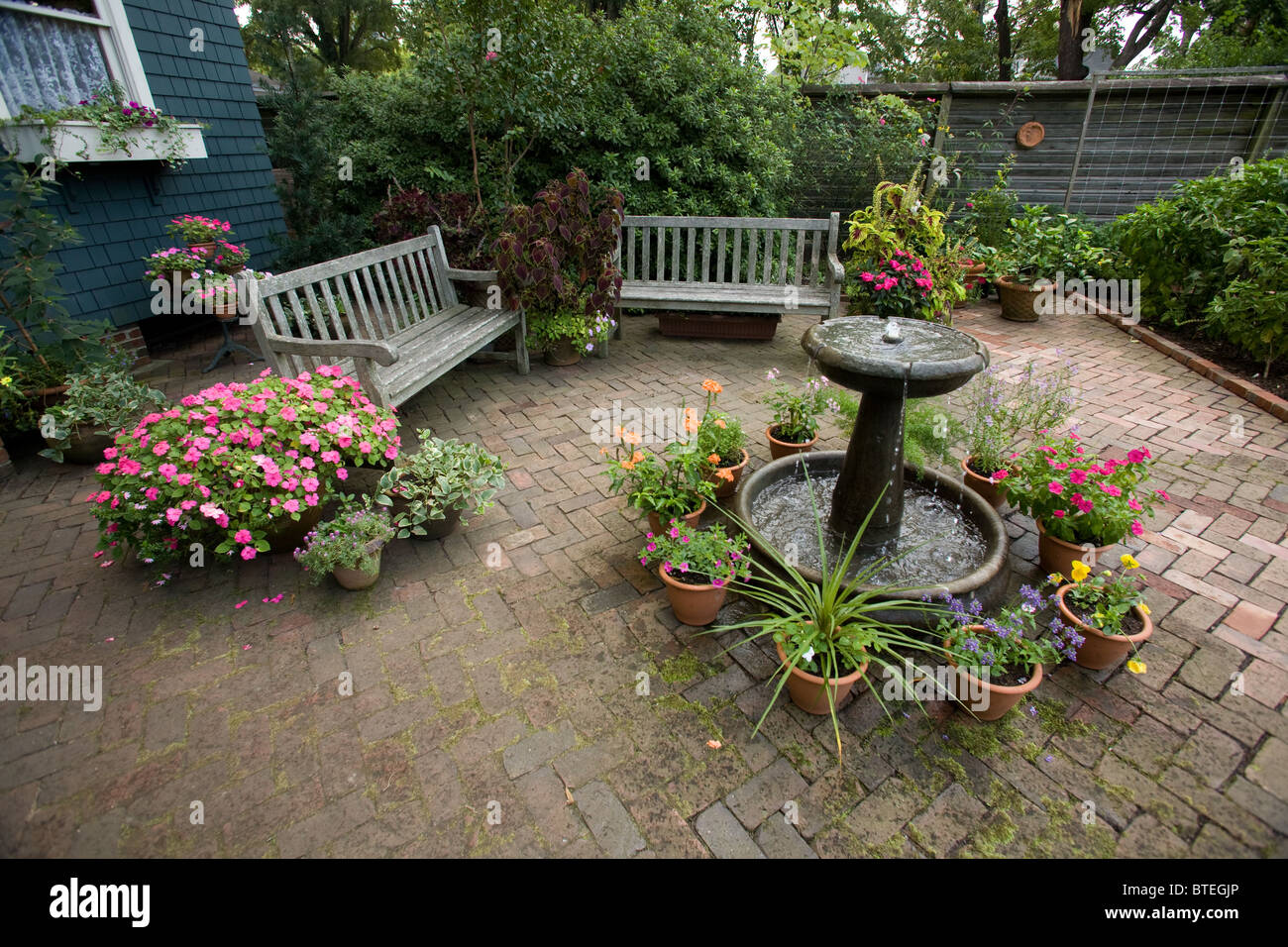 Brick courtyard with water fountain, potted plants and