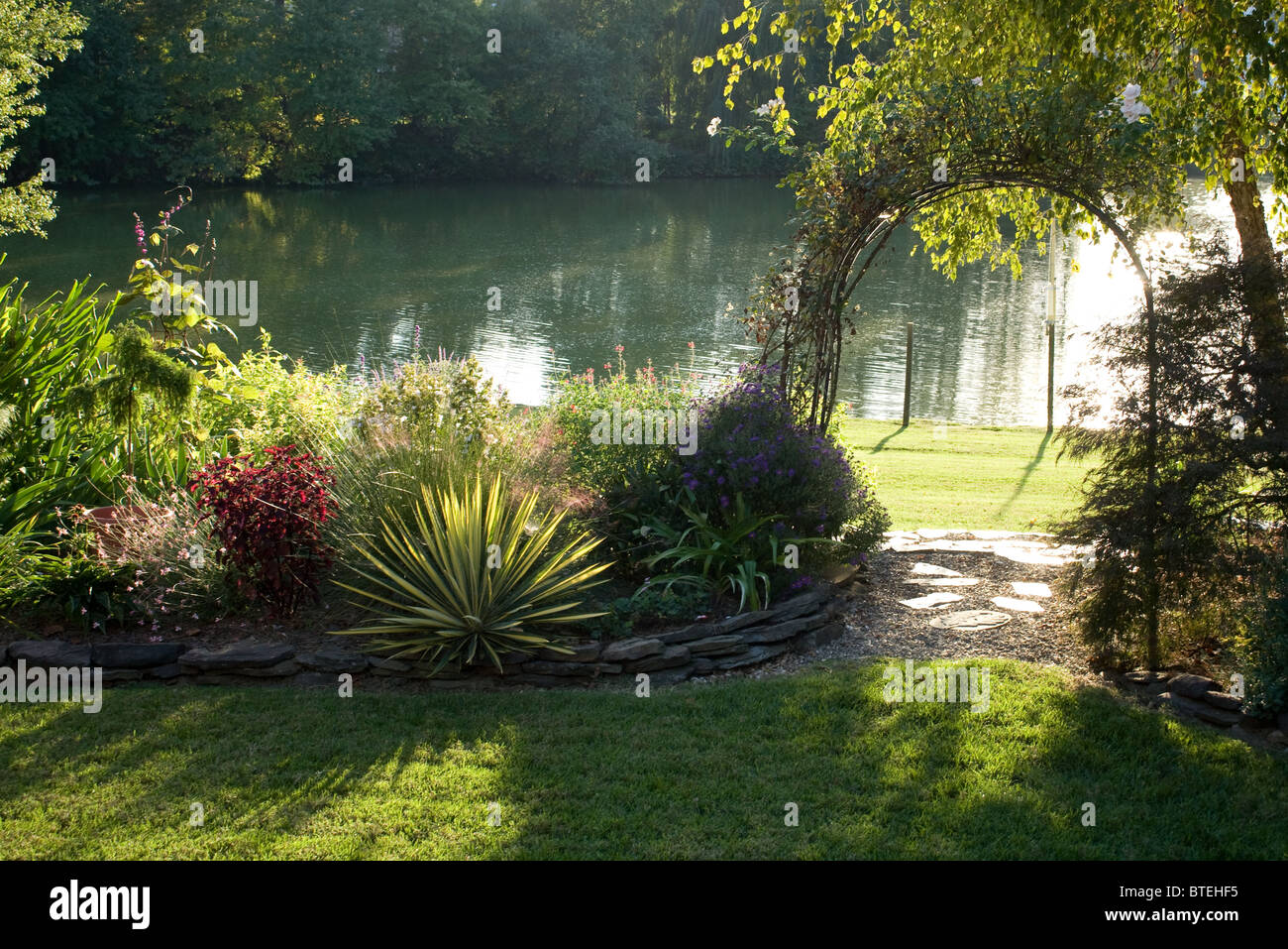 Garden trellis leading to the lake Stock Photo Alamy