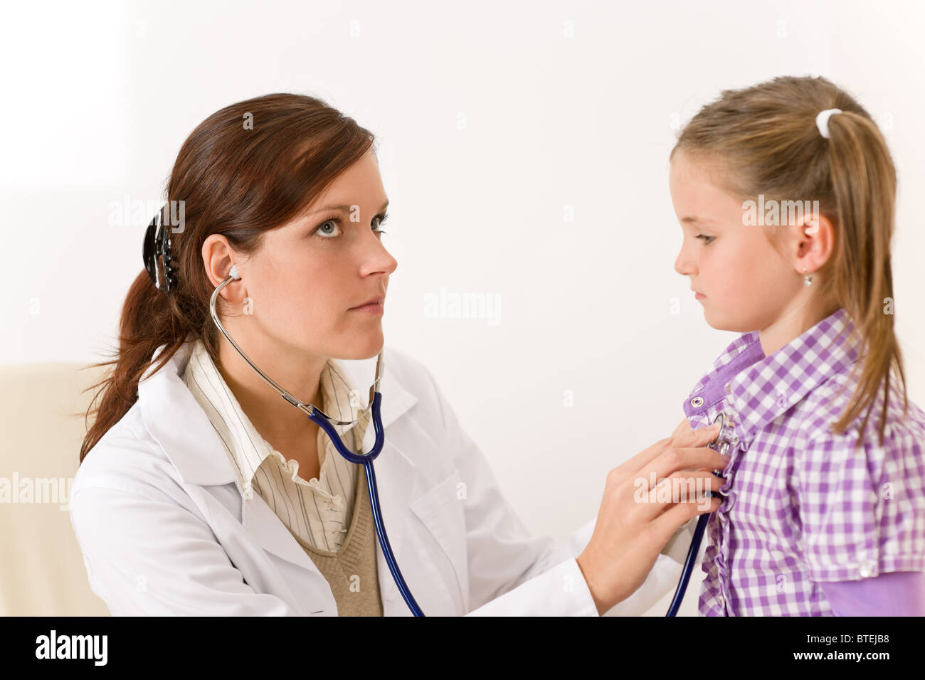 Female doctor examining child with stethoscope at clinic Stock Photo