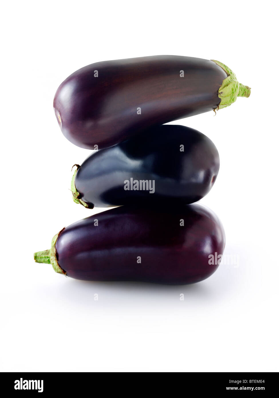 Fresh whole uncut aubergines or eggplants isolated against a white background Stock Photo