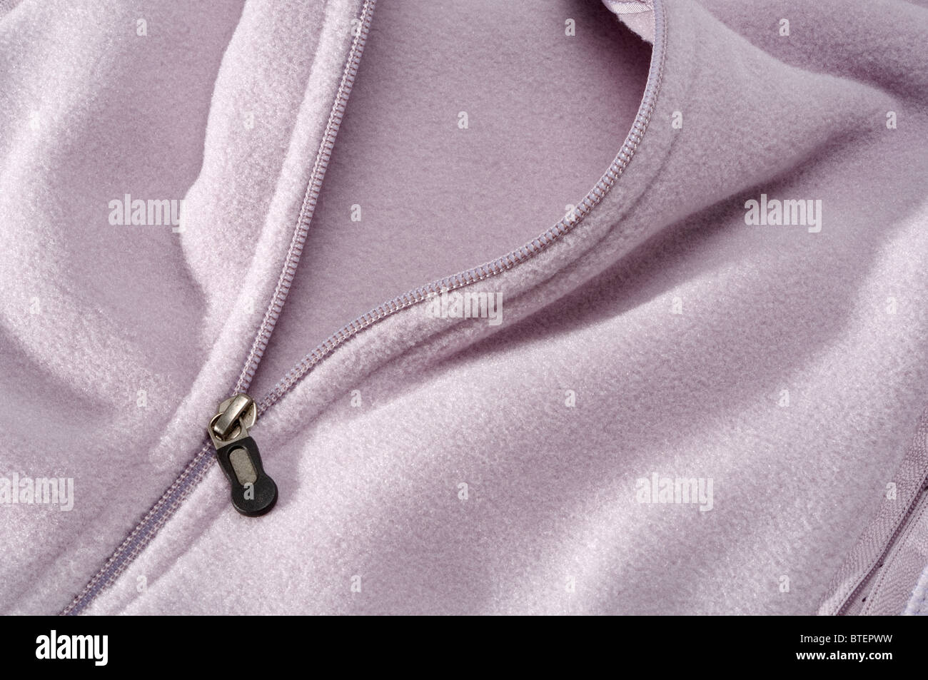 Close-up view of a pink pastel colored jacket and the zipper section opening Stock Photo