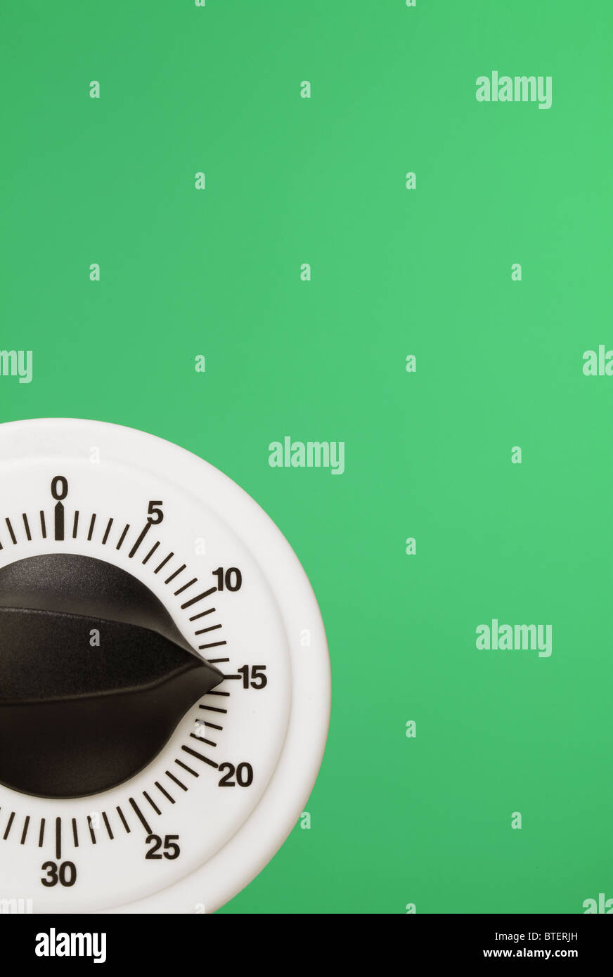 A count down timing device floating on a green background Stock Photo