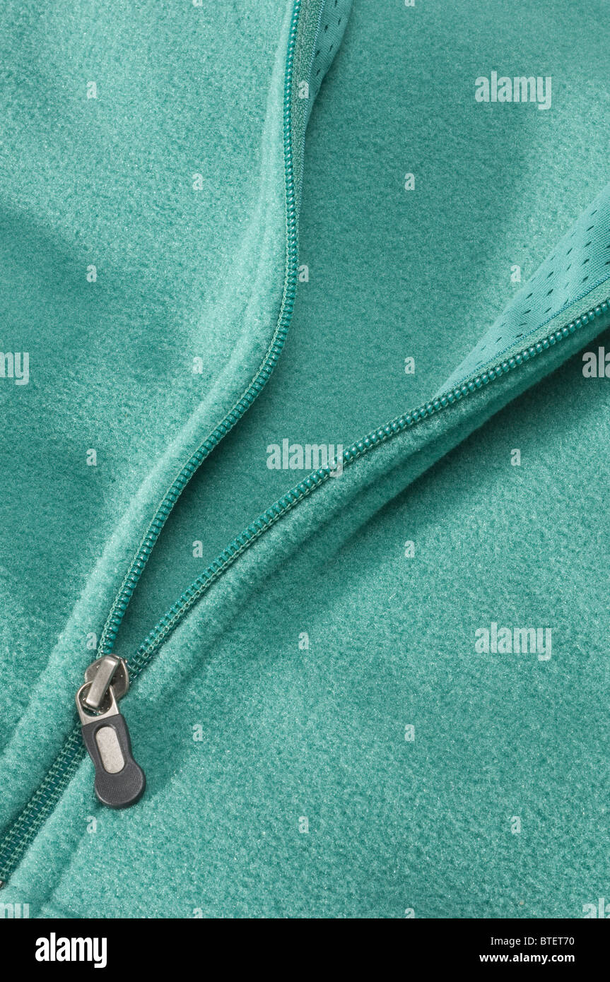 Close-up view of a green pastel colored jacket and the zipper section opening Stock Photo