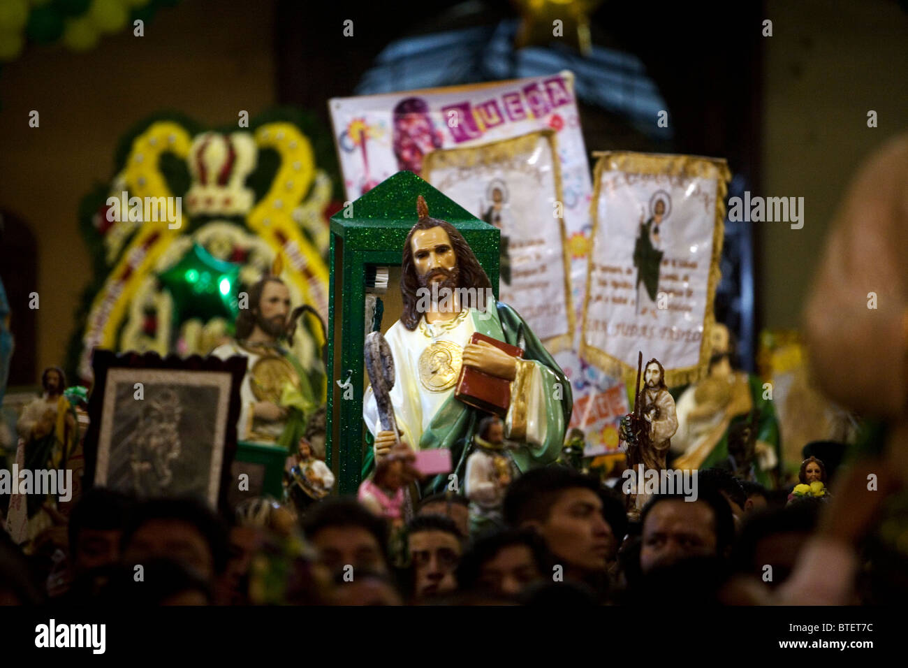 Mexicans hold sculptures and images of Saint Jude Thaddeus during a mass in Mexico City Stock Photo