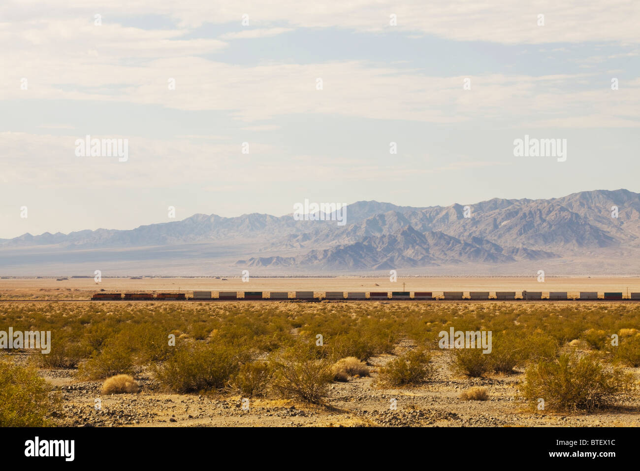 Long freight train on the floor of American southwest desert - California USA Stock Photo