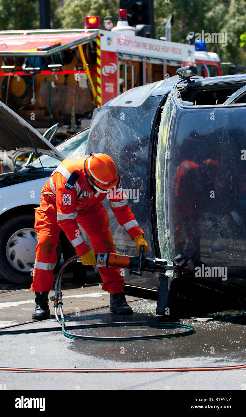 Emergency rescue workers cut a person out of a crashed vehicle. Stock Photo