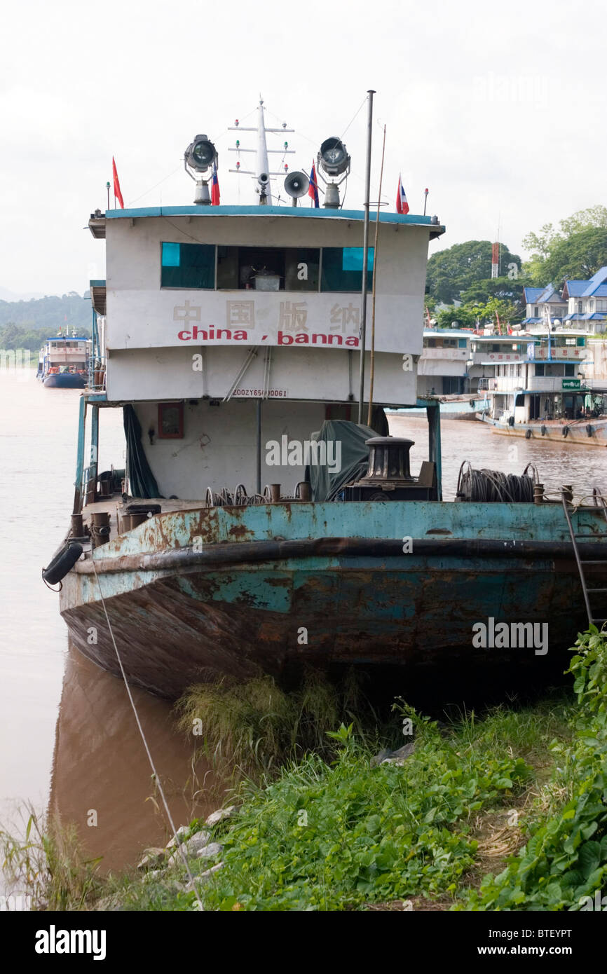 Chinese cargo boats from China used to import and export goods are docked on the Mekong River in Chiang Sean, Thailand. Stock Photo