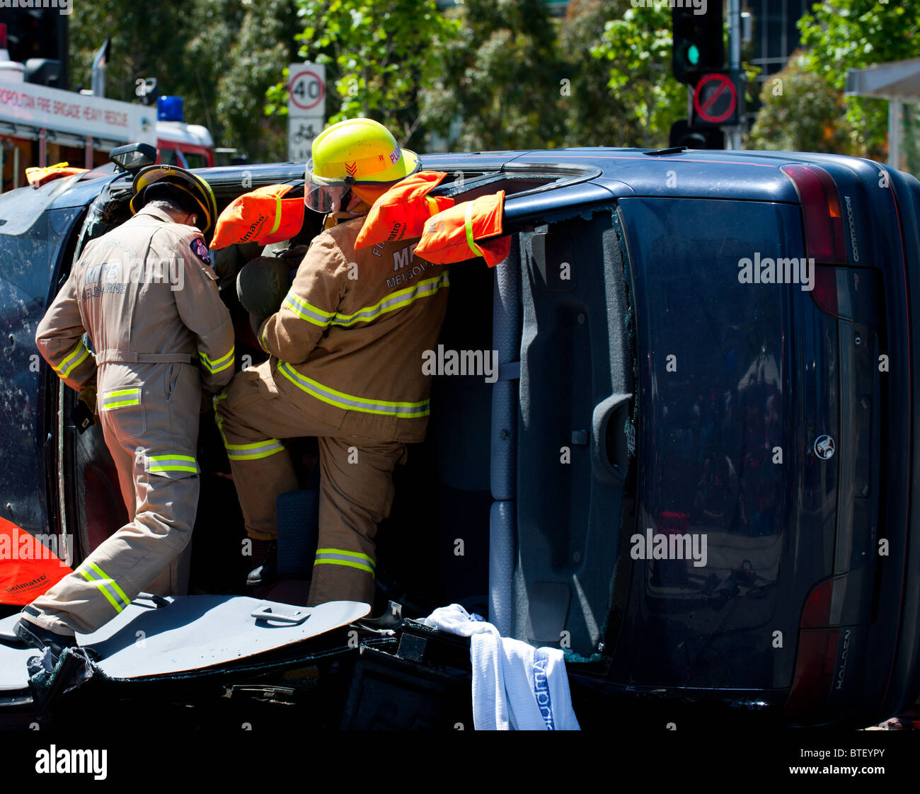 Emergency rescue workers cut a person out of a crashed vehicle. Stock Photo