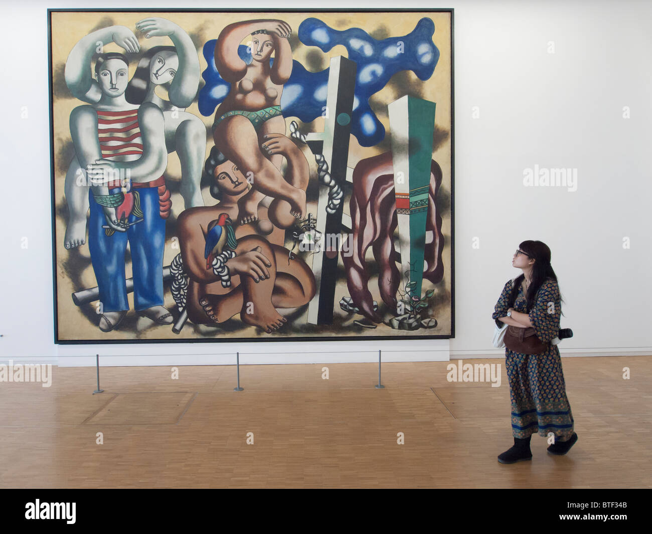 Woman looking at painting Composition aux deau Perroquets by Fernand Leger at Pompidou centre modern art museum in Paris France Stock Photo