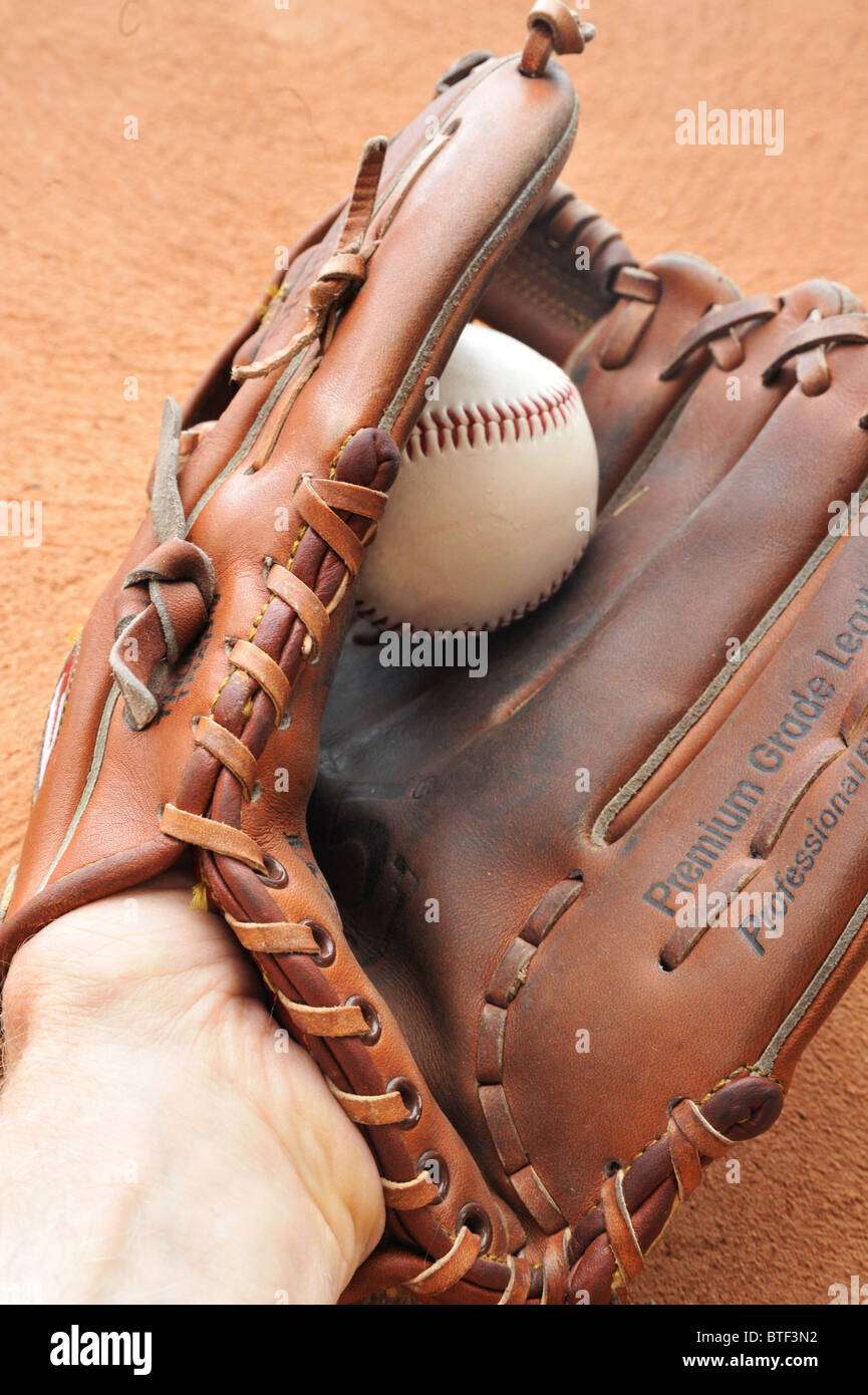Ball in fielder's glove, caught against outfield wall Stock Photo Alamy