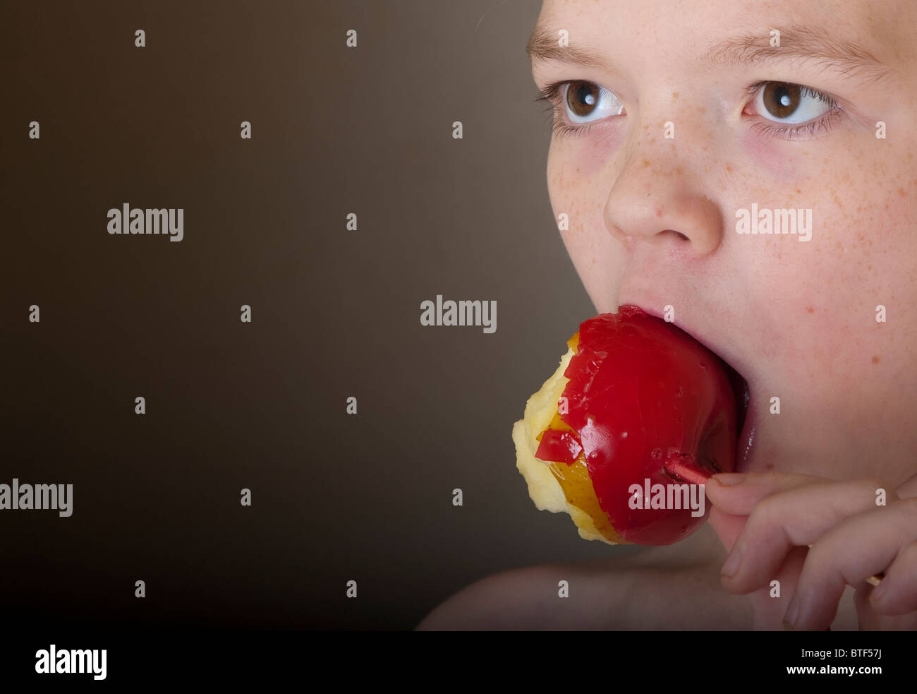 Child eating a toffee apple Stock Photo