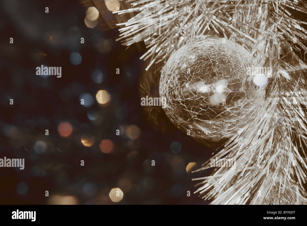 Glass christmas ball and coloured tinsel Stock Photo