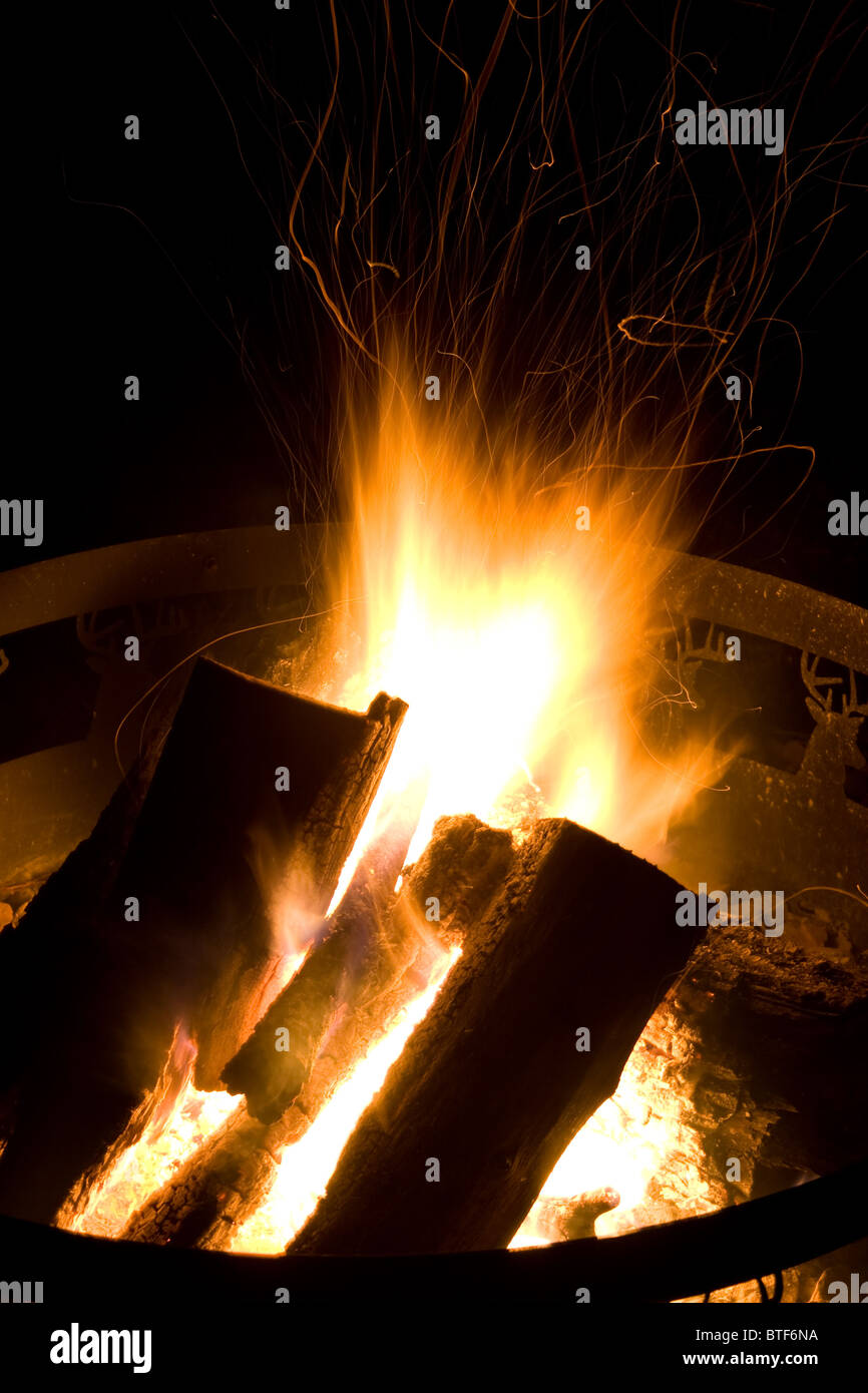 Camp Fire Giving Off Sparks at Night - Burning Wood Stock Photo