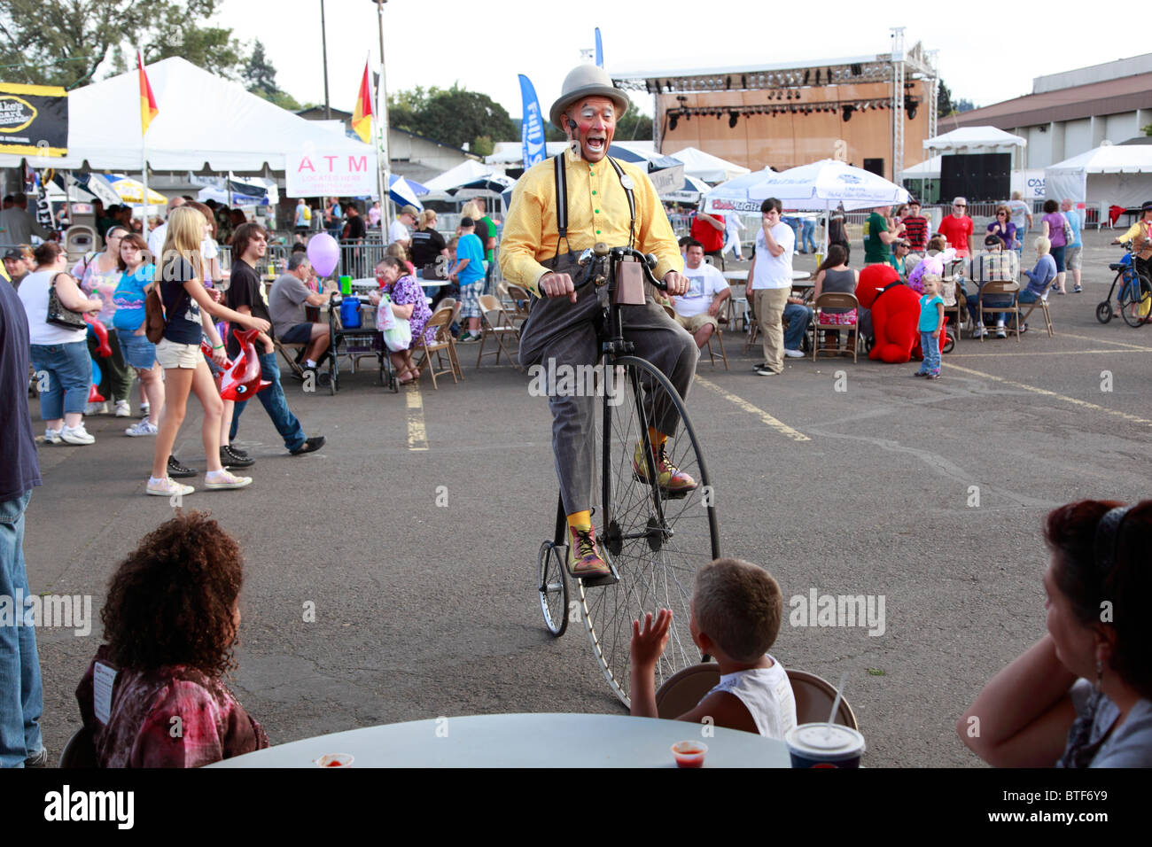 A clown on a unicycle entertains the Carnival crowd. Stock Photo