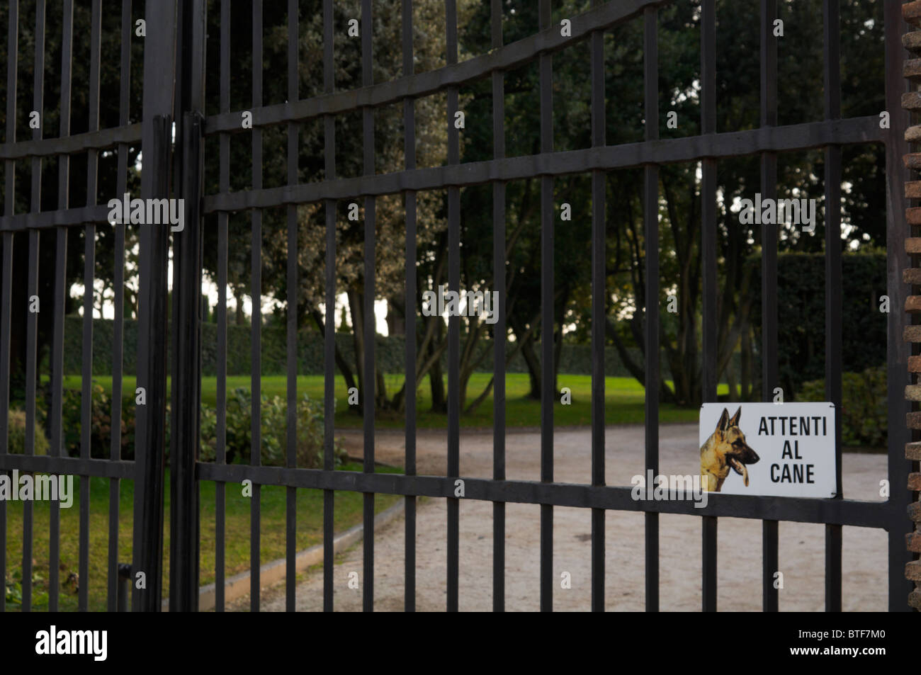 Gate with beware of the dog (attenti al cane) Italian sign. Stock Photo